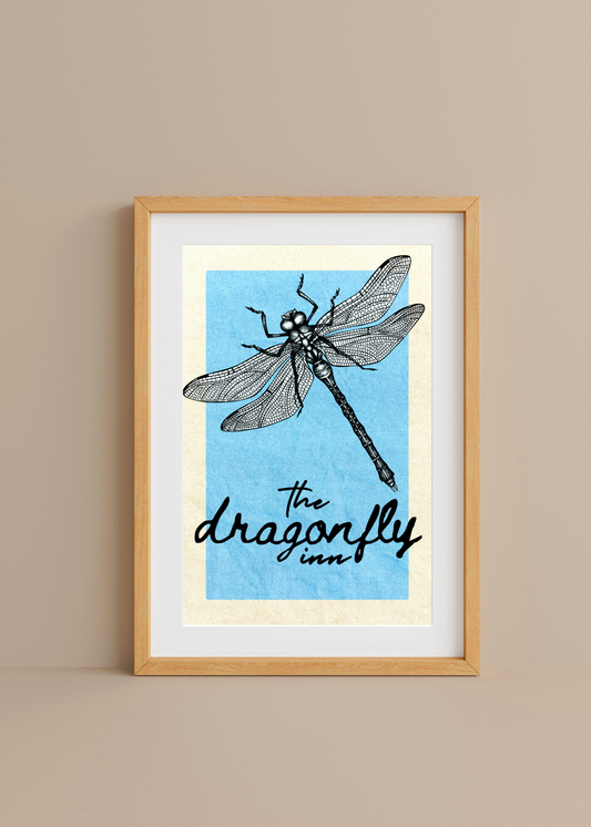 Framed artwork of a dragonfly illustration with text on a blue background