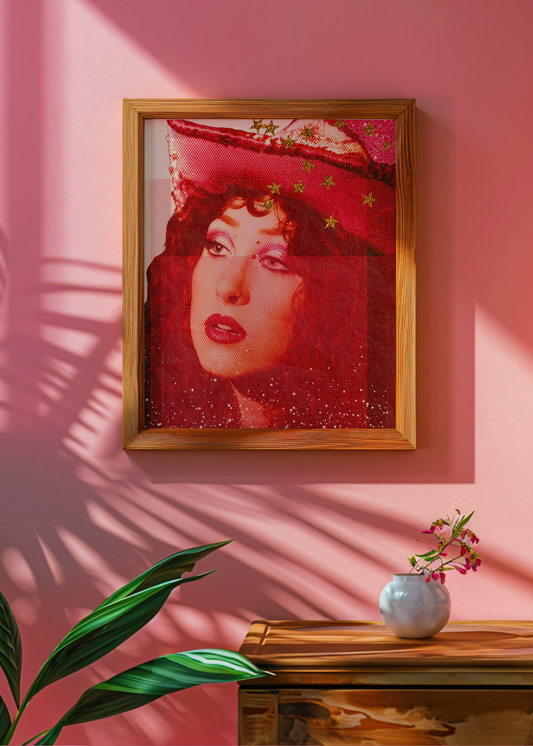Framed artwork of Chappel Roan with a red hat on a pink wall, with a vase and plant in the foreground.