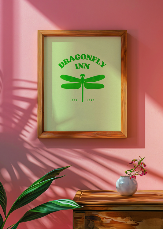 Framed print with 'Dragonfly Inn' design on a pink wall with a vase and plant.