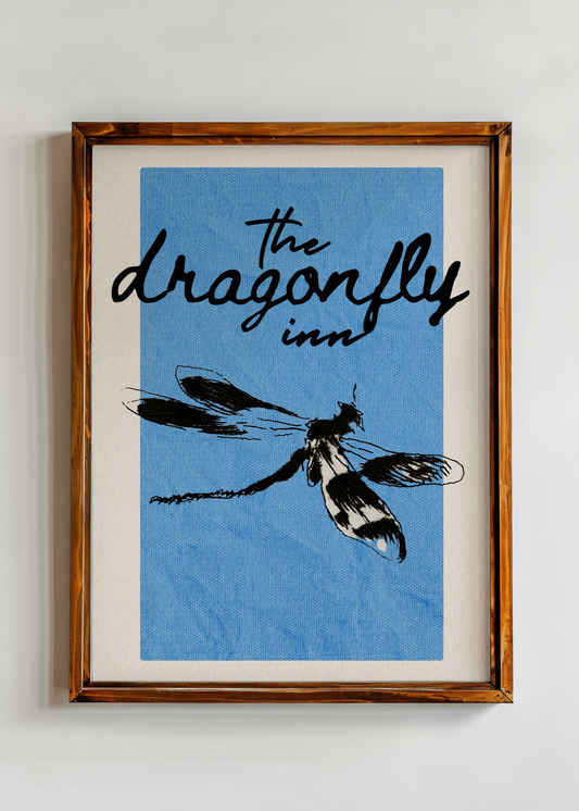 Framed artwork with 'The Dragonfly Inn' text and dragonfly illustration on a blue background.