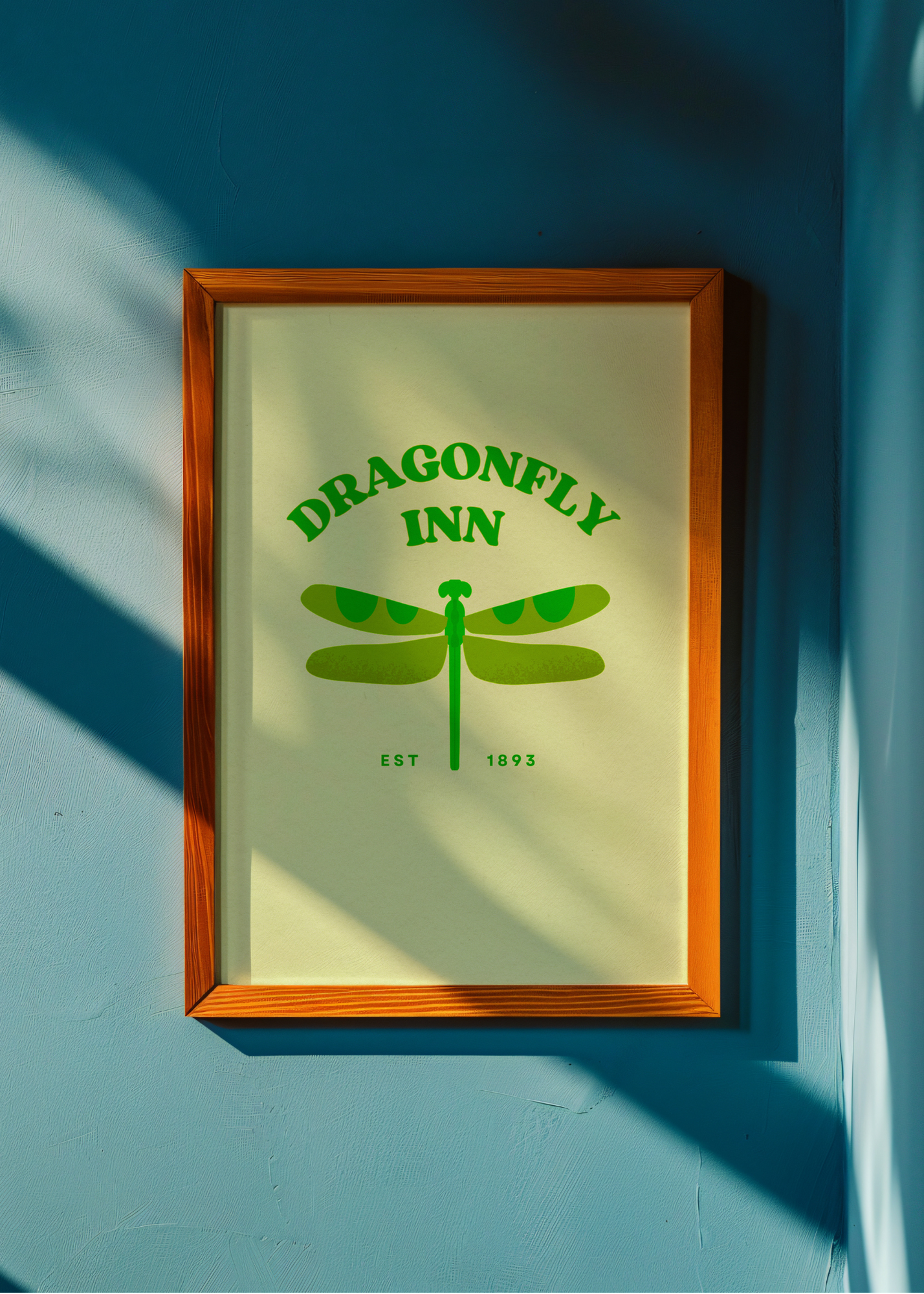 Framed artwork with 'Dragonfly Inn' logo on a blue wall